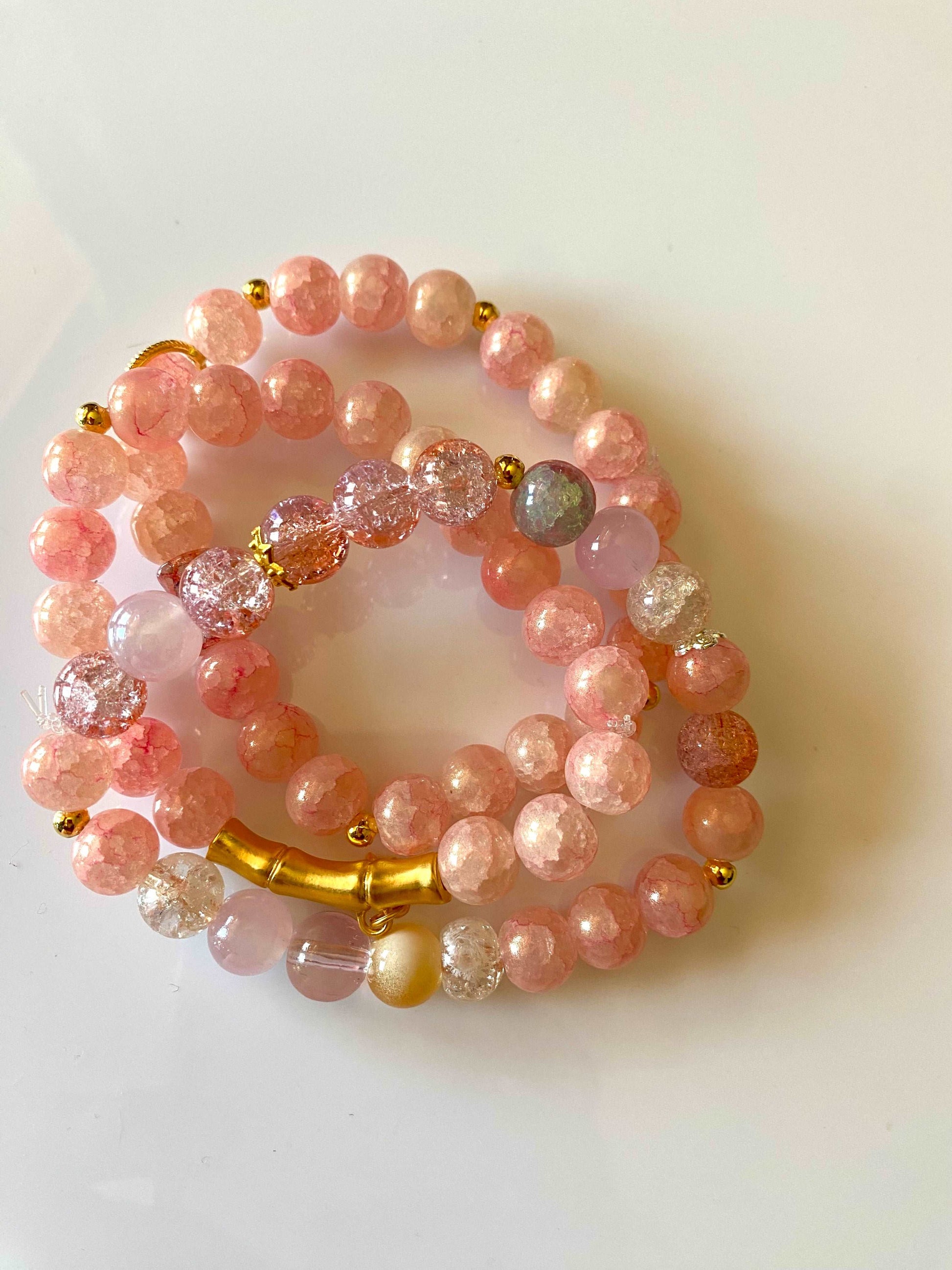 Peach glass bead bracelet.  With a touch of good charms. A set of three bracelets.  